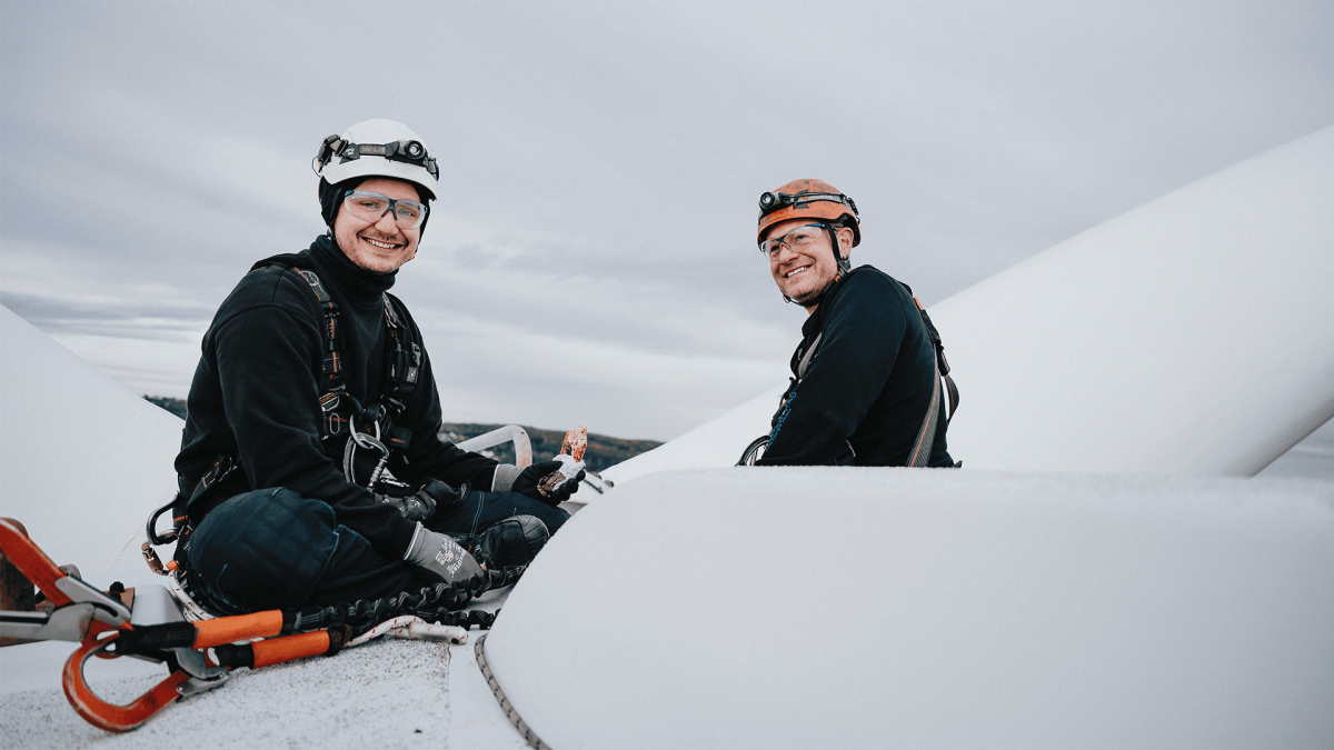 Two service technicians on top of a wind turbine, taking a break