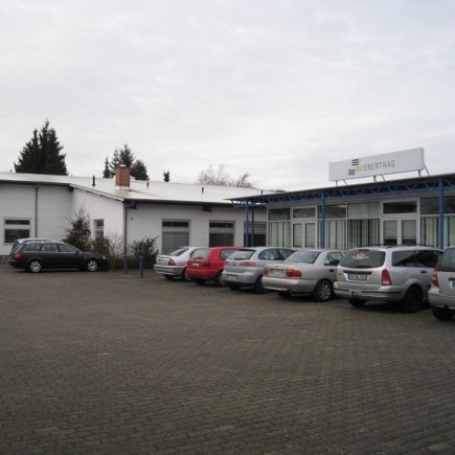 niedriges Industriegebäude mit parkenden Autos